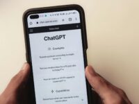 Close-up of hands holding a smartphone displaying the ChatGPT application interface on the screen.