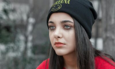 A contemplative young woman in a beanie, captured with a moody tone.
