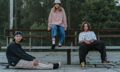Group of teenagers hanging out together with skateboards at a park.