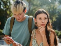 Confused multiracial couple searching way in map while discovering city together during summer holidays