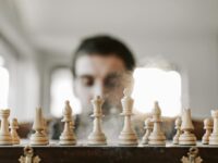 Close-up of a chessboard with chess pieces in action, representing strategy and concentration.