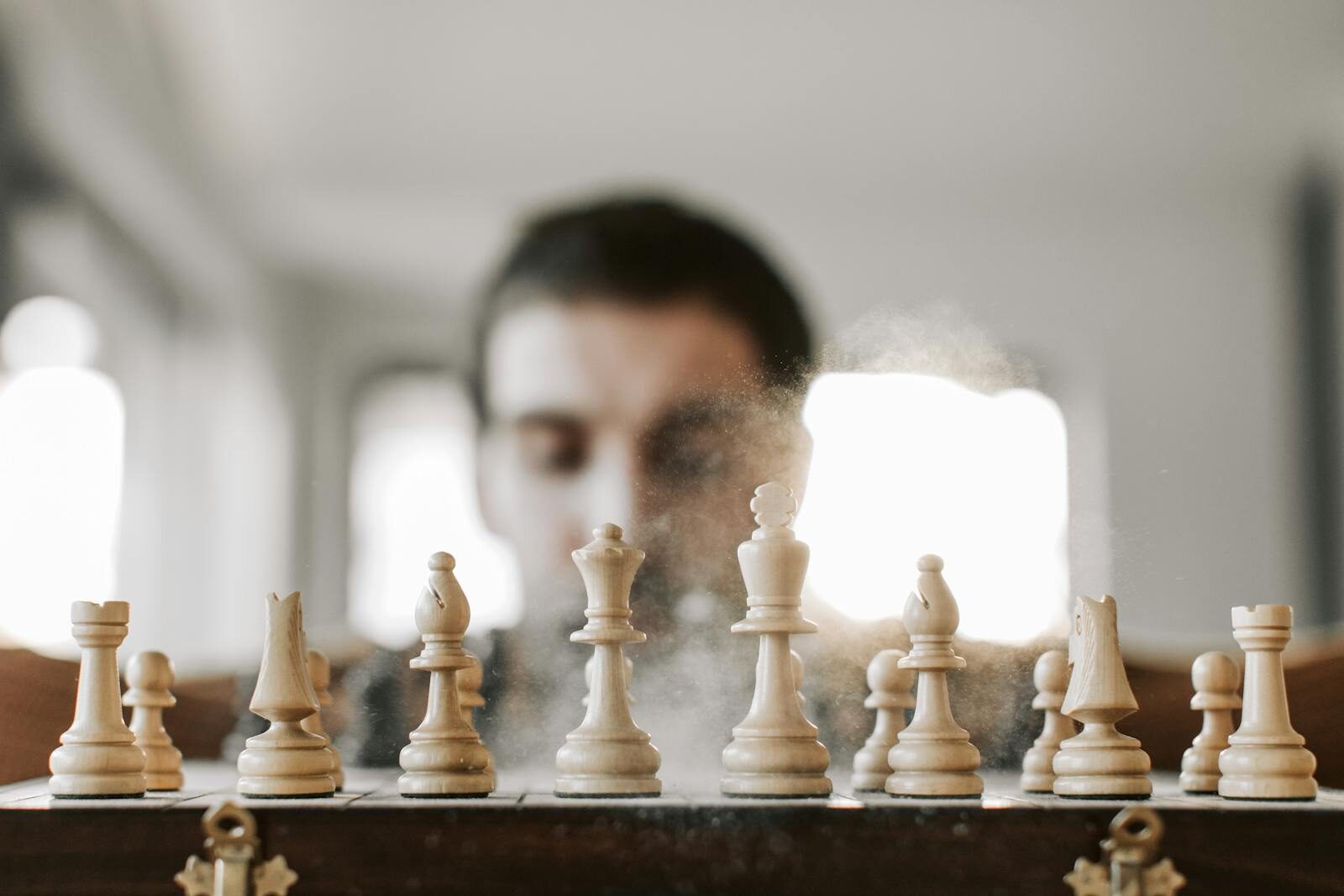 Close-up of a chessboard with chess pieces in action, representing strategy and concentration.