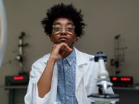 Portrait of a thoughtful scientist with eyeglasses in a laboratory setting.