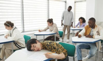 Students in a classroom taking an exam, showcasing diversity and focus.