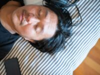 Close-up of a man relaxing with closed eyes and headphones, epitomizing tranquility.