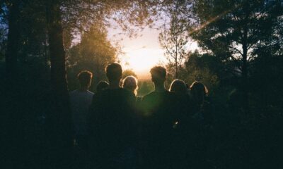 A group of friends enjoying a scenic sunset in a forest, capturing a moment of togetherness.