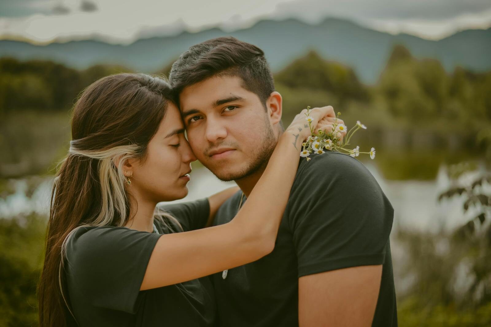 A young couple shares a tender embrace in San Cristóbal de las Casas, Mexico, with a scenic backdrop.